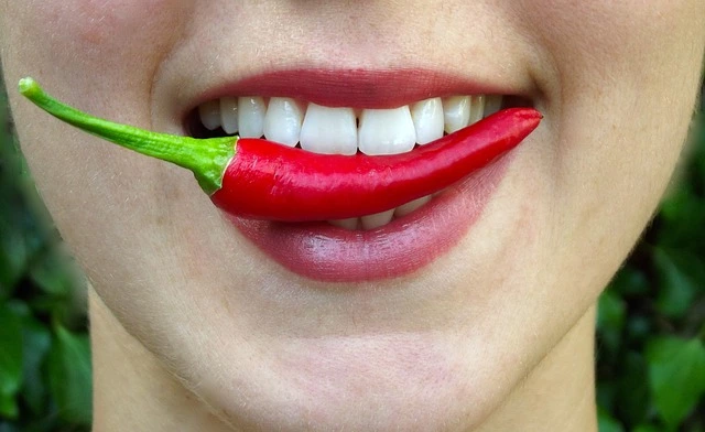 an asian biting a chili